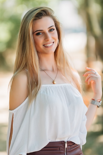 Outdoors portrait of beautiful young brunette girl in park