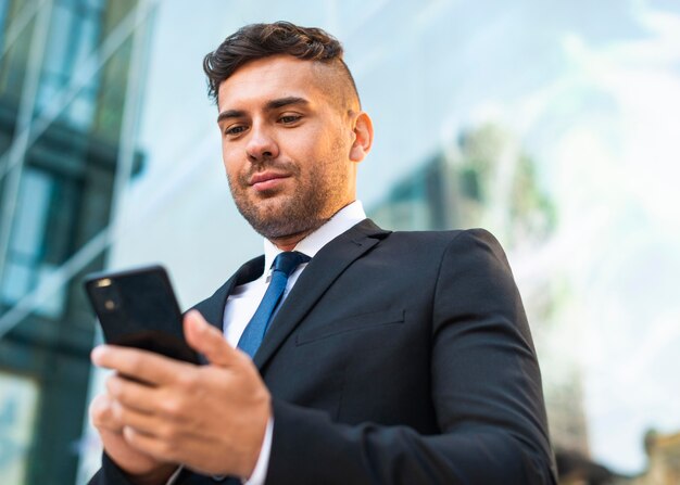 Outdoors successful business person looking at the phone