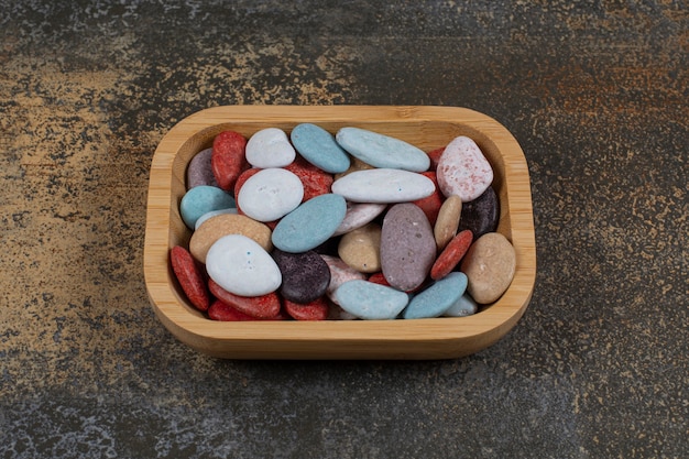 Free Photo oval shaped stone candies on wooden plate.