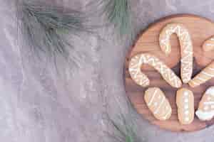 Free photo ovale and stick shape gingerbread cookies on a wooden board