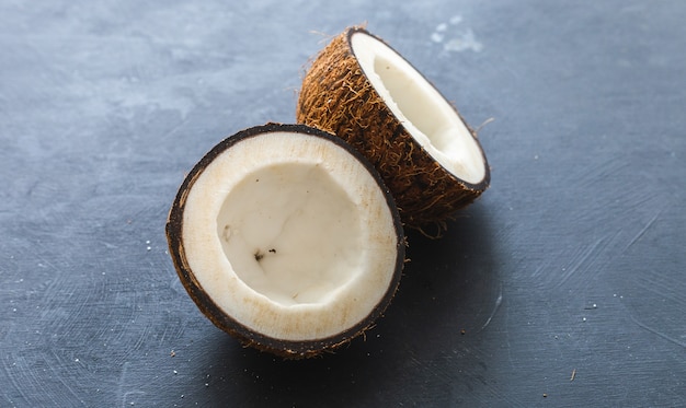 Free photo overhead closeup shot of cut coconuts on a grey table