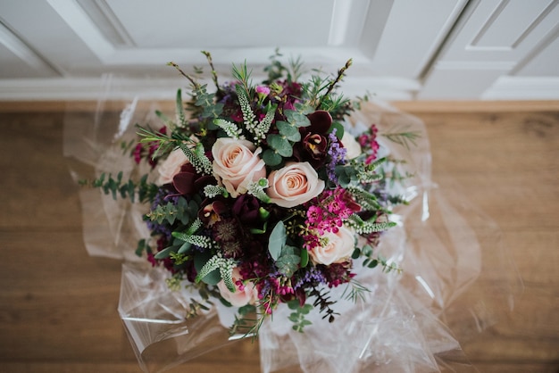 Overhead closeup shot of  a wedding flower bouquet on a wooden floor