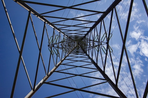 Overhead power line under a blue sky and sunlight