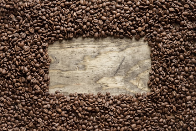 Overhead shot of a coffee beans frame over a wooden surface great for background or writing text