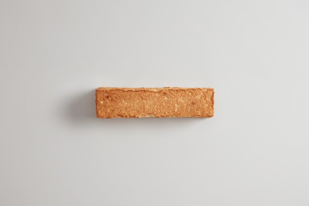 Overhead shot of crusty slice of bread on white  background. Fresh baked product. Health eating and dieting concept. Food background. Buckwheat bread without yeast. Pastry item for eating