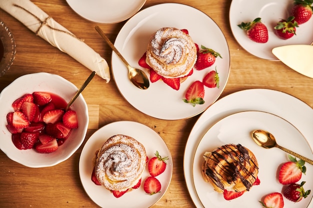 Overhead shot of delicious cream puff with strawberries and chocolate on a wooden table