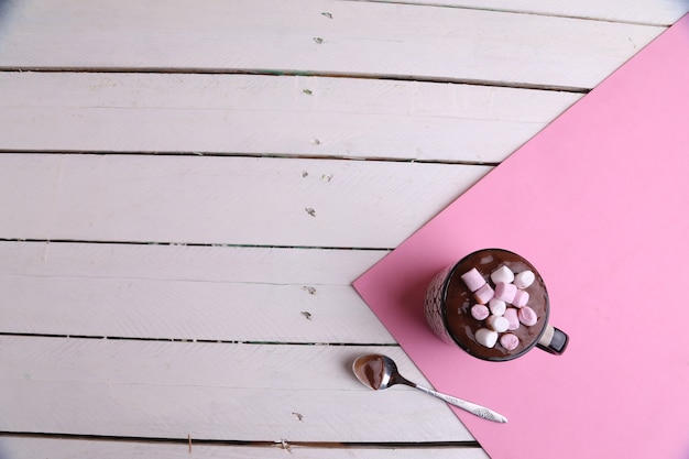 Free photo overhead shot of a mug of hot chocolate with marshmallows and a spoon on a kitchen table