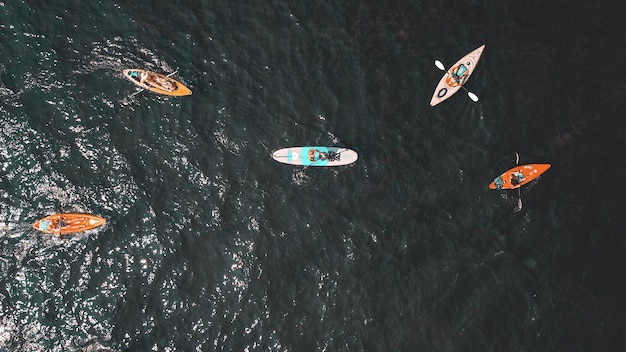 Overhead shot of people in small rowboats in the water