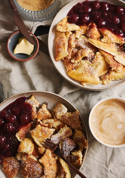 Overhead vertical closeup view of delicious fluffy pancakes with cherry and powdered sugar