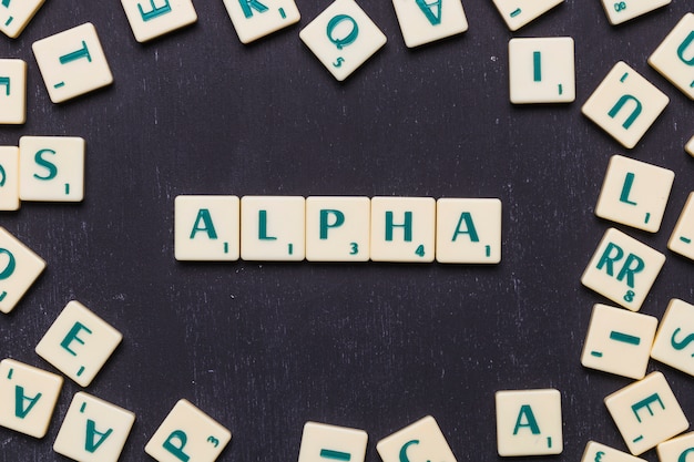 Overhead view of alpha text on scrabble letters over black backdrop