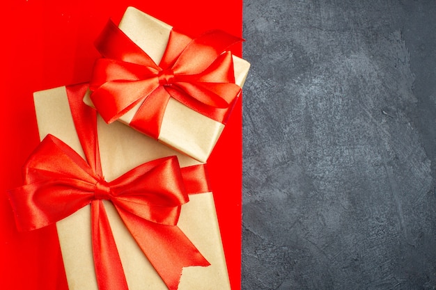 Free photo overhead view of beautiful gifts with bow-shaped ribbon on red and black background