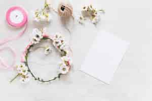 Free photo an overhead view of blank white paper with flower wreath