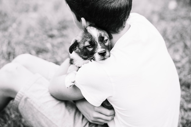 Free photo an overhead view of boy embracing his lovely puppy