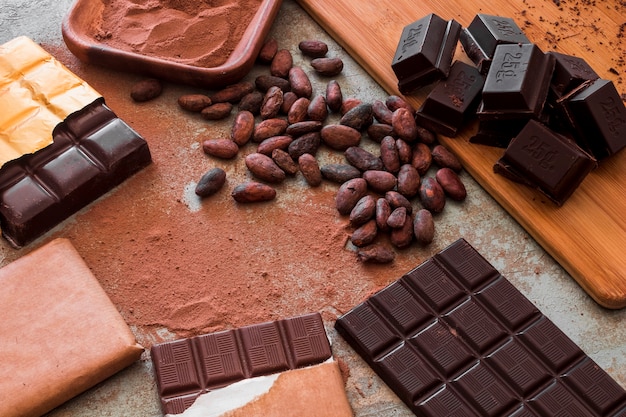 Free Photo overhead view of chocolate bars with cocoa powder and raw beans