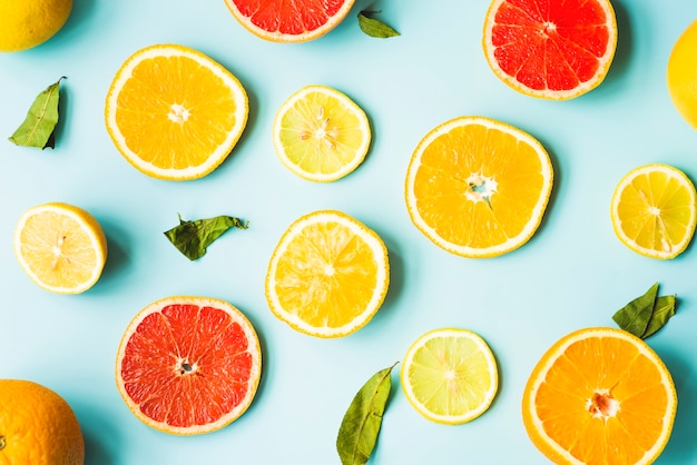 Overhead view of citrus fruit slices on blue background