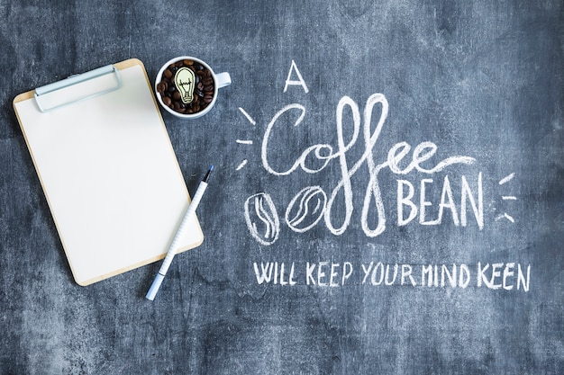 Free Photo overhead view of clipboard and mug with coffee beans on chalkboard with text