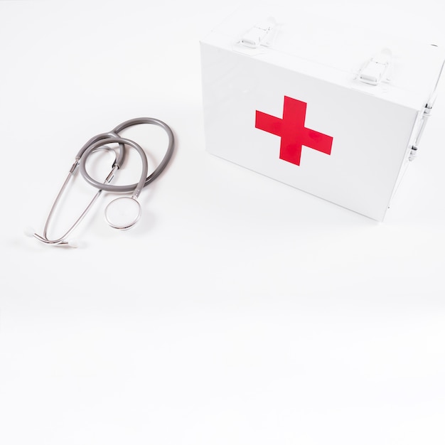 Free photo overhead view of closed first aid kit and stethoscope on white background