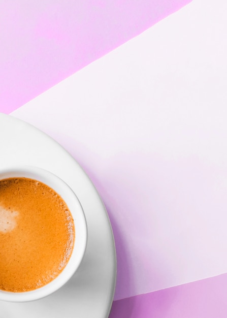 Free photo an overhead view of coffee cup on pink background