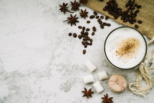 Free Photo overhead view of coffee cup with star anise; coffee beans; marshmallow and macaroon