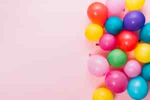 Free photo an overhead view of colorful balloons over pink background