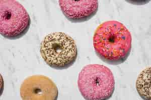 Free photo an overhead view of colorful donuts on marble textured backdrop