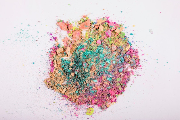 Overhead view of colorful face powders on white background