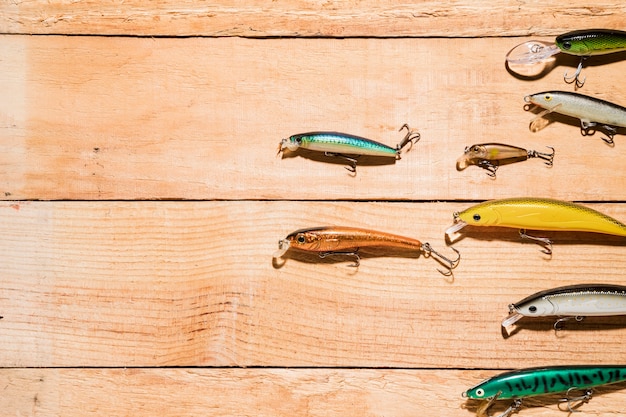 Free photo an overhead view of colorful fishing baits on wooden desk