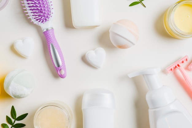 An overhead view of cosmetics products with hairbrush and razor