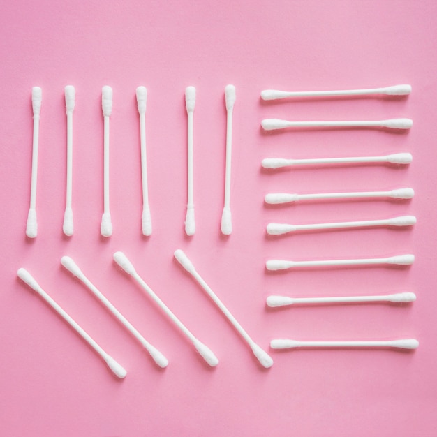 Free photo overhead view of cotton swab arranged on pink background