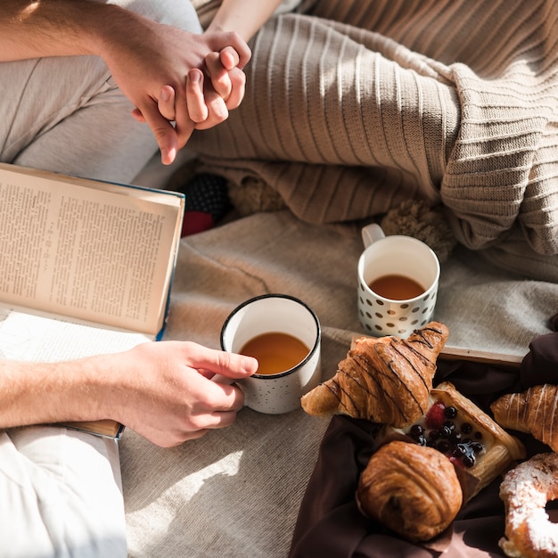 An overhead view of couple's holding each other's hand at breakfast