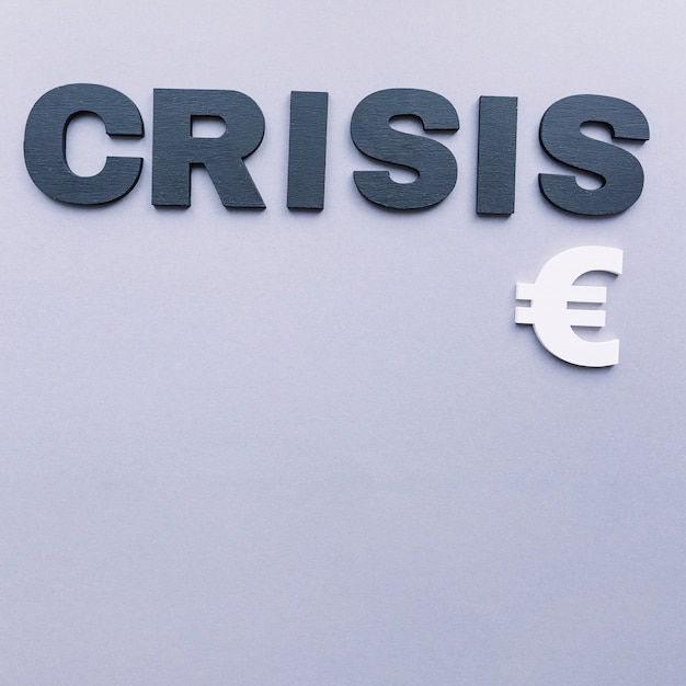 Free photo overhead view of crisis word with euro sign on grey background