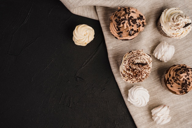 Free photo overhead view of cupcakes and whipped creams on cloth