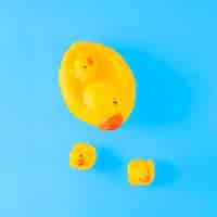 Free photo an overhead view of cute yellow rubber duck with ducklings against blue background