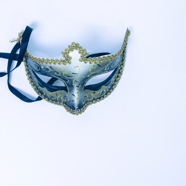 An overhead view of decorative venetian mask on white backdrop