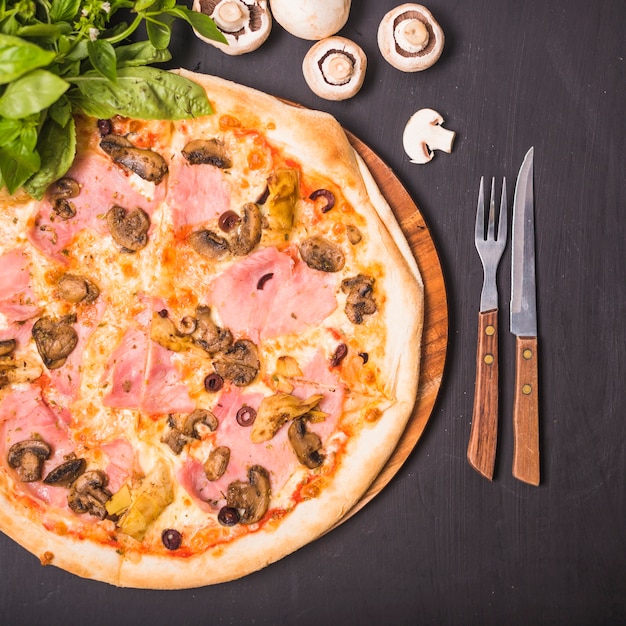 An overhead view of delicious homemade pizza with basil and mushroom