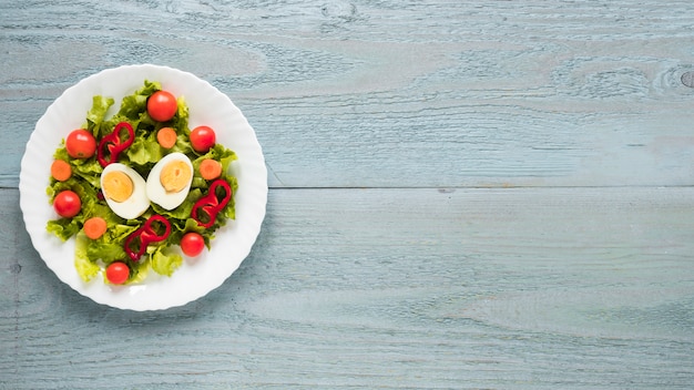 An overhead view of delicious salad in white plate