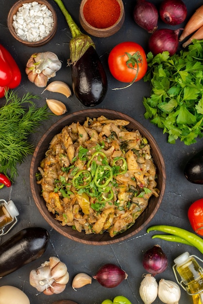 Overhead view of eggplant meal fresh vegetables green bundle pepper on dark color background