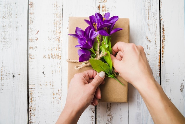 An overhead view of fake purple flowers on the parcel tied with string