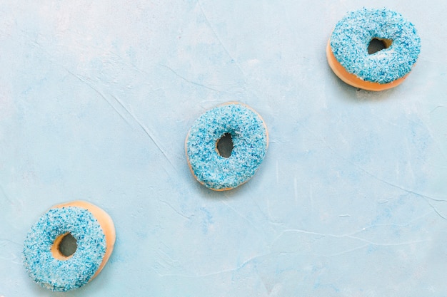 Free Photo overhead view of fresh donuts on blue background