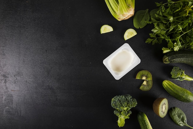 Overhead view of fresh green vegetables on black background