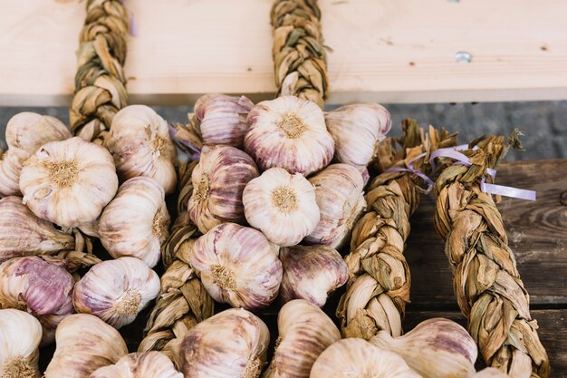 An overhead view of garlic bulb braids on wooden table