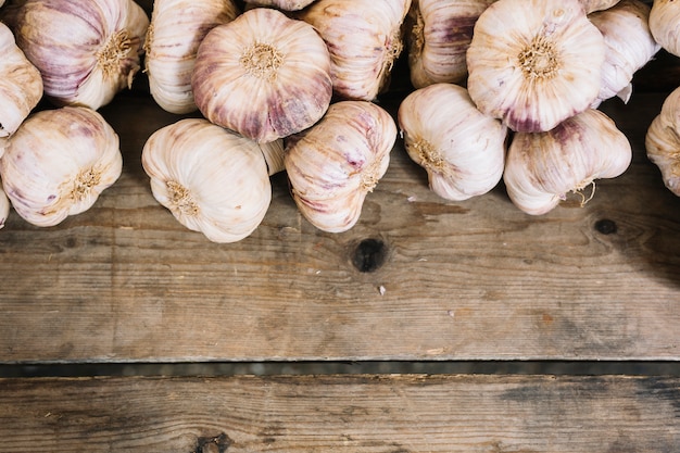 An overhead view of garlic bulbs on wooden table