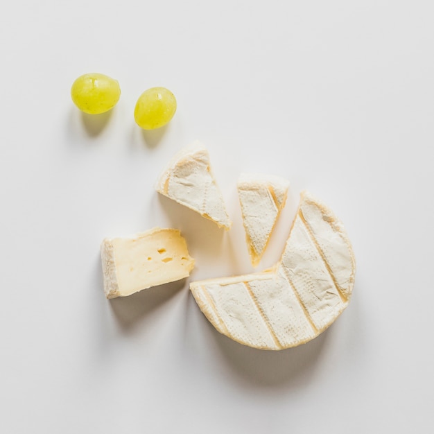 An overhead view of grapes and cheese blocks isolated on white background