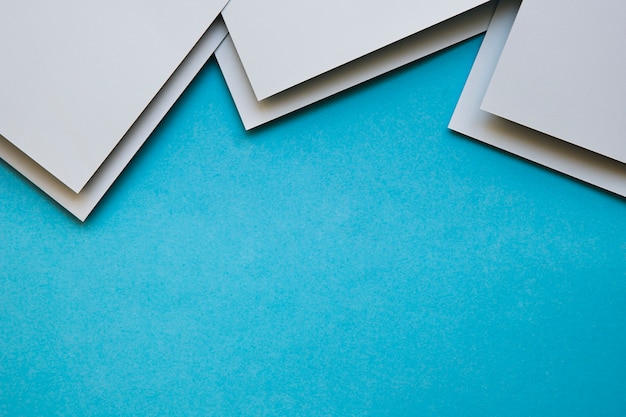 Overhead view of grey craftpapers on blue background