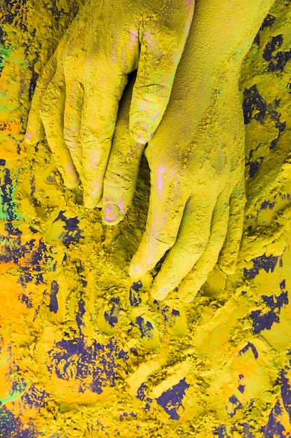 Free photo an overhead view of hand covered with yellow powder paint