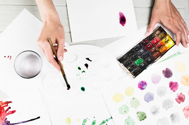 Free Photo overhead view of hand mixing watercolor for painting