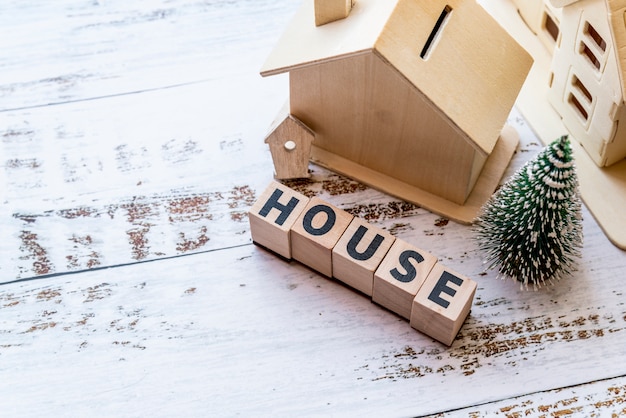 Free Photo an overhead view of house model with house wooden blocks and christmas tree on white textured surface