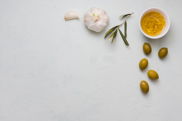 Free photo an overhead view of infused olive oil and garlic in bowl on concrete backdrop