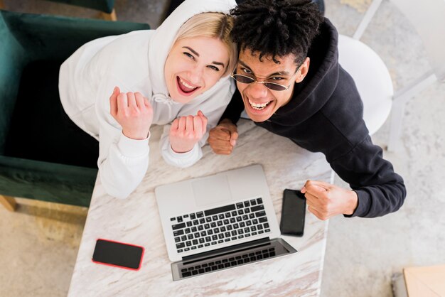 An overhead view of interracial teenage couple clenching their fist looking up