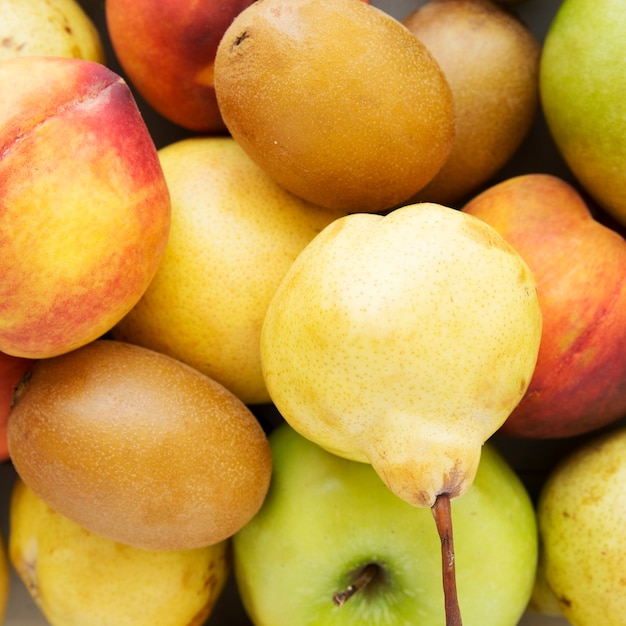 Free photo an overhead view of kiwi; peach; apple and pear fruits